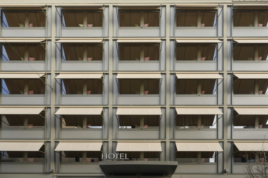 Fassade des JAMS Music Hotel in München mit 54 individuell gefertigten Fallarmmarkisen von Rankl Sonnenschutz